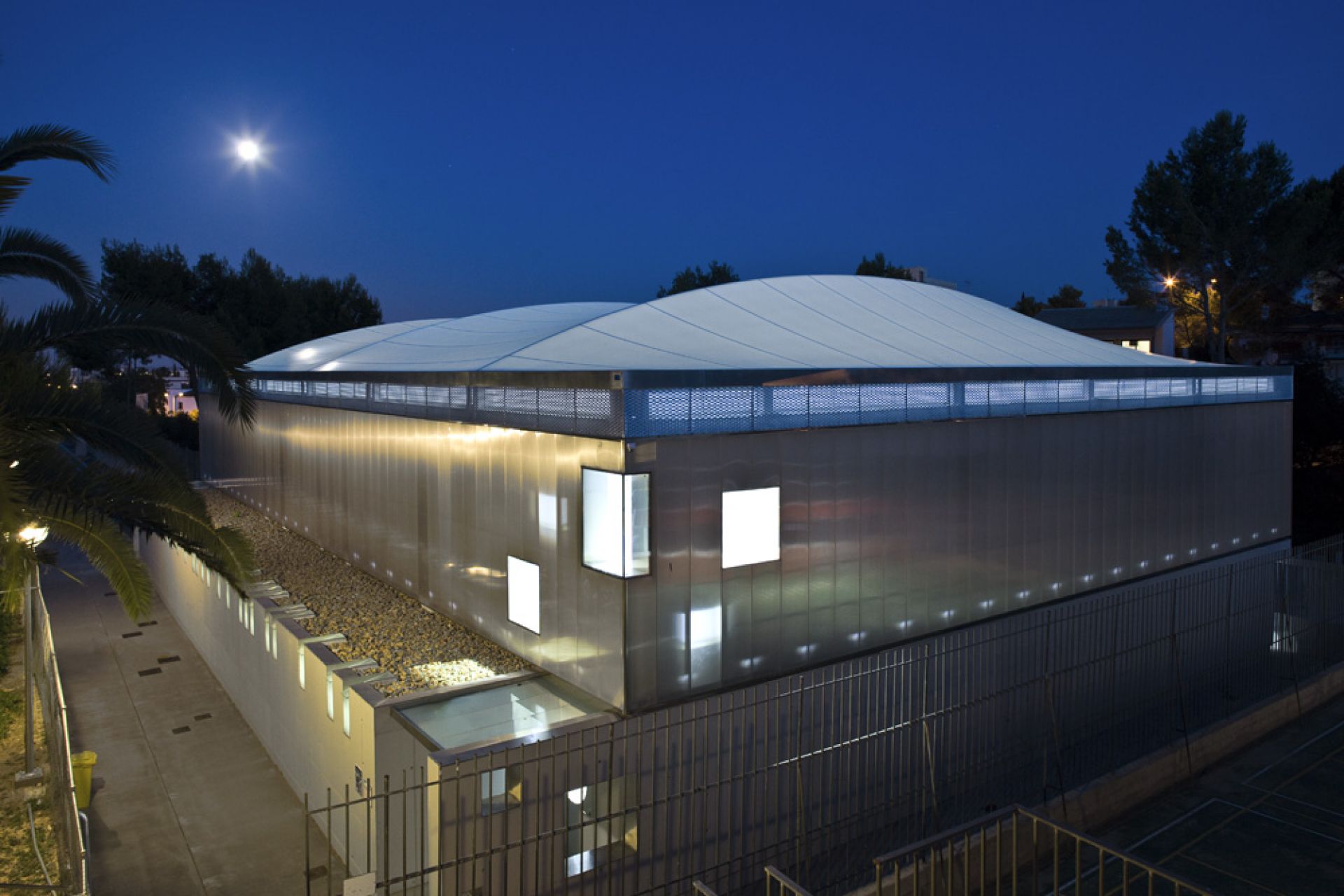 night image of the exterior of the sports center cover